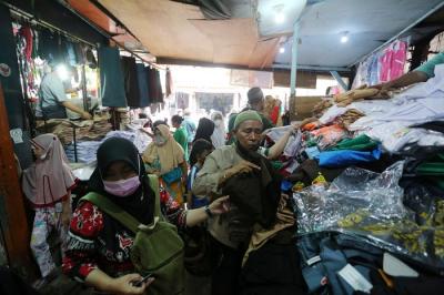 Calon pembeli memilih seragam dan atribut sekolah di Pasar Mester Jatinegara, Jakarta Timur, Selasa (4/1/2022).