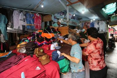 Calon pembeli memilih seragam dan atribut sekolah di Pasar Mester Jatinegara, Jakarta Timur, Selasa (4/1/2022).