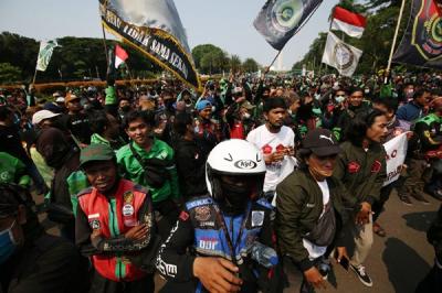Sejumlah pengemudi ojek online membentangkan spanduk saat aksi unjuk rasa di Jakarta, Rabu (5/1/2022).