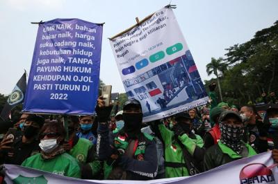 Sejumlah pengemudi ojek online membentangkan spanduk saat aksi unjuk rasa di Jakarta, Rabu (5/1/2022).