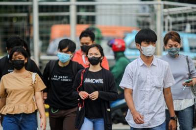 Pekerja melintasi jalur pedestrian di kawasan Sudirman saat jam pulang kerja di Jakarta, Rabu (5/1/2022).