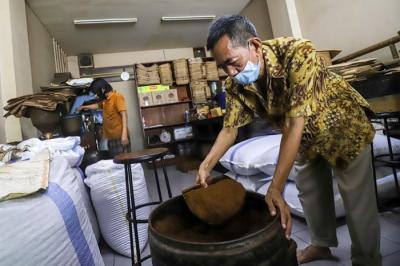 Sejumlah pekerja menggiling dan membungkus kopi di Toko Kopi Sari Murni, Jatinegara, Jakarta Timur, Kamis (6/1/2022).