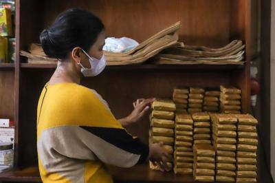 Sejumlah pekerja menggiling dan membungkus kopi di Toko Kopi Sari Murni, Jatinegara, Jakarta Timur, Kamis (6/1/2022).