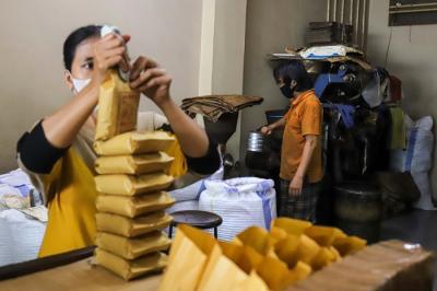 Sejumlah pekerja menggiling dan membungkus kopi di Toko Kopi Sari Murni, Jatinegara, Jakarta Timur, Kamis (6/1/2022).