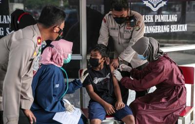 Tenaga kesehatan menyuntikan vaksin Covid-19 ke seorang anak dibawah kolong Jalan Layang Gaplek, Pamulang, Tangerang Selatan, Banten, Kamis (6/1/2022).