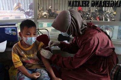 Tenaga kesehatan menyuntikan vaksin Covid-19 ke seorang anak dibawah kolong Jalan Layang Gaplek, Pamulang, Tangerang Selatan, Banten, Kamis (6/1/2022).