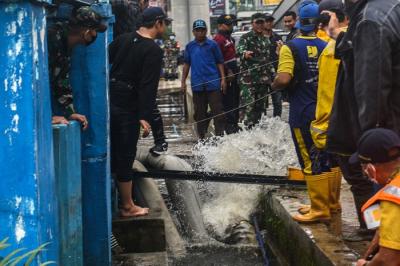 Uji coba layanan bergerak mobil pompa menyedot air di Kolam Retensi Simpang Polda Palembang, Jumat (7/1/2022).