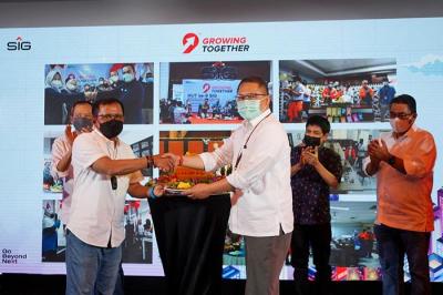 Komisaris Utama SIG, Rudiantara (Kanan) menyerahkan potongan tumpeng kepada Direktur Utama SIG, Donny Arsal pada peringatan HUT ke-9 SIG di Jakarta.