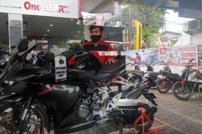 Petugas membersihkan sepeda motor yang di panjang di salah satu dealer motor di kawasan Pasar Minggu, Jakarta Selatan, Senin (10/1/2022).