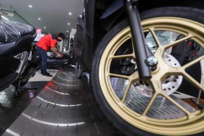 Petugas membersihkan sepeda motor yang di panjang di salah satu dealer motor di kawasan Pasar Minggu, Jakarta Selatan, Senin (10/1/2022).