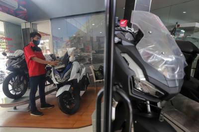 Petugas membersihkan sepeda motor yang di panjang di salah satu dealer motor di kawasan Pasar Minggu, Jakarta Selatan, Senin (10/1/2022).