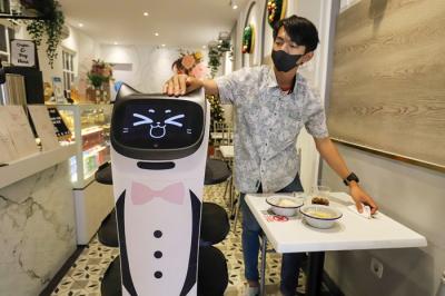 Pekerja mengoperasikan robot pramusaji bernama Kitty di Rasa Koffie di kawasan Pasar Baru, Jakarta Pusat, Jumat (14/1/2022).