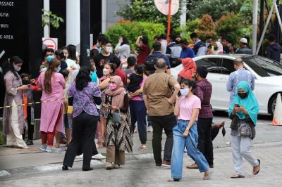 Sejumlah karyawan dan penghuni apartemen berhamburan keluar gedung saat terjadi gempa di kawasan Jakarta, Jumat (14/1/2022).