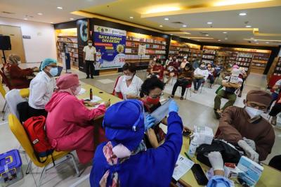 Vaksinator menyuntikkan vaksin Covid-19 dosis ketiga (booster) di Toko Buku Gramedia, Matraman, Jakarta Timur, Senin (17/1/2022).