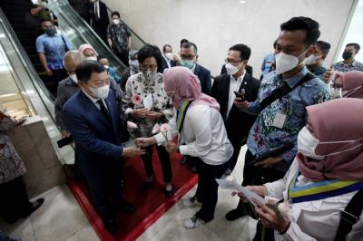Perempuan KOPRIPBMII membagikan bunga kepada para anggota DPR usai rapat paripurna ke-13 masa sidang 2021-2022 di Gedung Nusantara II.