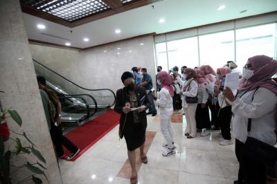 Perempuan KOPRIPBMII membagikan bunga kepada para anggota DPR usai rapat paripurna ke-13 masa sidang 2021-2022 di Gedung Nusantara II.