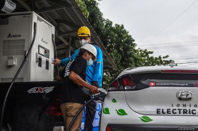 Petugas mengisi bahan bakar saat acara peresmian Stasiun Pengisian Kendaraan Listrik Umum (SPKLU) di Jalan Demang Daun Palembang, Selasa (18/1/2022).