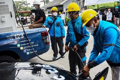 Petugas mengisi bahan bakar saat acara peresmian Stasiun Pengisian Kendaraan Listrik Umum (SPKLU) di Jalan Demang Daun Palembang, Selasa (18/1/2022).