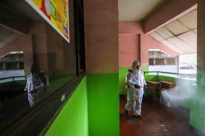 Petugas Palang Merah Indonesia (PMI) melakukan penyemprotan disinfektan pada ruang laboratorium di SMP Negeri 43, Jakarta Selatan, Kamis (20/1/2022).