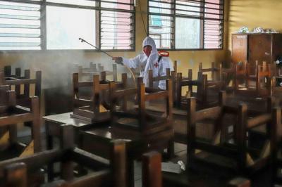 Petugas Palang Merah Indonesia (PMI) melakukan penyemprotan disinfektan pada ruang laboratorium di SMP Negeri 43, Jakarta Selatan, Kamis (20/1/2022).