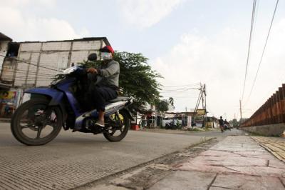 Warga melintas di jalan terusan yang belum selesai di kawasan Pasar Minggu, Jakarta Selatan, Kamis (20/1/2022).