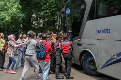 Petugas Polisi melarang ratusan pengungsi Afghanistan turun dari bus di depan kantor Amnesty Internasional Indonesia, Menteng, Jakarta Pusat, Rabu (19/1/2022).