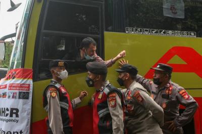 Petugas Polisi melarang ratusan pengungsi Afghanistan turun dari bus di depan kantor Amnesty Internasional Indonesia, Menteng, Jakarta Pusat, Rabu (19/1/2022).