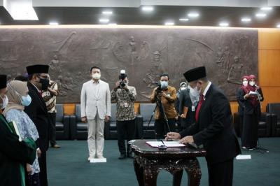 Ketua MPR Bambang Soesatyo (kanan) menyaksikan Harvey Malaiholo menandatangani berita acara pelantikan disaksikan Dian Istiqomah di Gedung Nusantara IV.