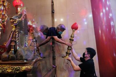 Pengurus Klenteng mendandani Rupang setelah dimandikan di Klenteng Xian Ma, Makssar, Minggu (23/1/2022).