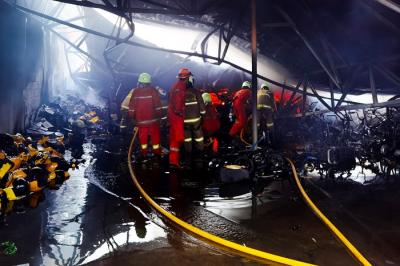 Petugas berusaha memadamkan Kebakaran yang melanda bangunan gudang di kawasan Meruya Utara, Kecamatan Kembangan, Jakarta Barat, Senin (24/1/2022).