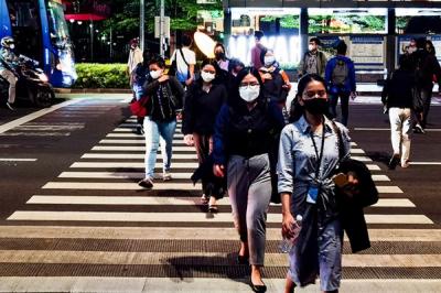 Suasana para pekerja yang berjalan pada saat jam pulang kantor di kawasan Jalan Sudirman, Jakarta Pusat, Kamis (27/1/2022).