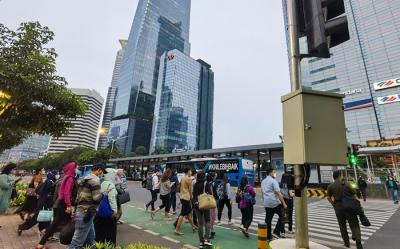 Suasana para pekerja yang berjalan pada saat jam pulang kantor di kawasan Jalan Sudirman, Jakarta Pusat, Kamis (27/1/2022).