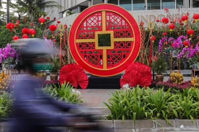 Warga berfoto dengan latar belakang ornamen bernuansa Imlek yang di pasang di kawasan Bundaran Hotel Indonesia, Jakarta Pusat, Sabtu (29/1/2022).