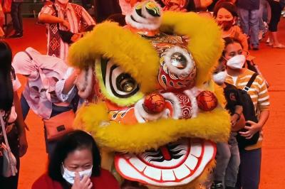 Anak-anak dan sejumlah pengunjung memberikan angpao kepada barongsai untuk menyambut perayaan Imlek di pusat perbelanjaan, Jakarta Barat, Minggu (30/1/2022).