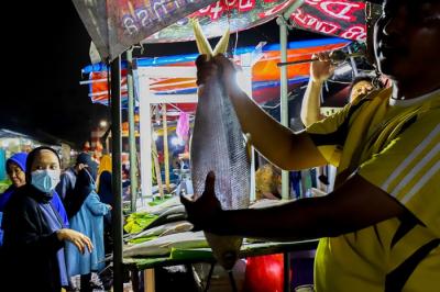 Pedagang ikan bandeng saat melayani pembeli untuk disajikan sebagai hidangan khas saat Hari Raya Imlek di Jakarta Barat, Minggu (30/1/2022).