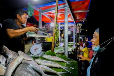 Pedagang ikan bandeng saat melayani pembeli untuk disajikan sebagai hidangan khas saat Hari Raya Imlek di Jakarta Barat, Minggu (30/1/2022).