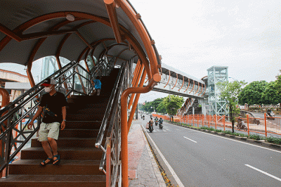 Warga melintas di Jembatan Penyebrangan Orang (JPO) Abbidin, Jl. Kolonel Sugiono, Banjir Kanal Timur (BKT), Jakarta Timur, Rabu (2/2/2022).