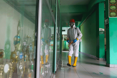 Petugas Palang Merah Indonesia (PMI) menyemprotkan disinfektan di salah satu ruang kelas di SMPN 97, Jakarta Timur, Kamis (3/2/2022).
