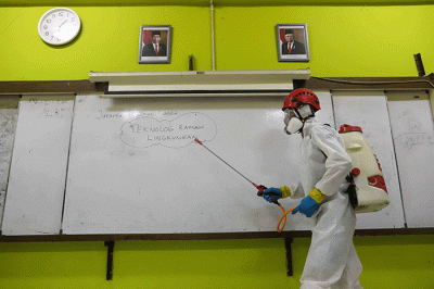 Petugas Palang Merah Indonesia (PMI) menyemprotkan disinfektan di salah satu ruang kelas di SMPN 97, Jakarta Timur, Kamis (3/2/2022).