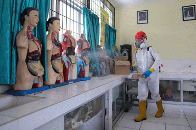Petugas Palang Merah Indonesia (PMI) menyemprotkan disinfektan di salah satu ruang kelas di SMPN 97, Jakarta Timur, Kamis (3/2/2022).