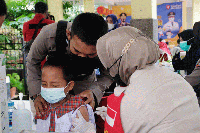 Petugas kesehatan menyuntikan vaksin Covid-19 kepada anak saat mengikuti 'Road Show' vaksin Covid-19 bagi anak usia 6-11 tahun di SD Kristen Hati Kudus.