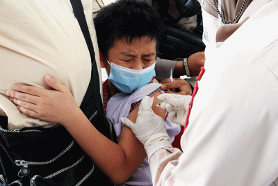 Petugas kesehatan menyuntikan vaksin Covid-19 kepada anak saat mengikuti 'Road Show' vaksin Covid-19 bagi anak usia 6-11 tahun di SD Kristen Hati Kudus.