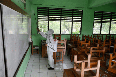Petugas PMI Jakarta Pusat menyemprotkan cairan disinfektan di SMPN 4, Jakarta, Jumat (4/2/2022).
