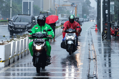 Sejumlah pengendara melintas saat hujan deras di Jalan MH Thamrin, Jakarta Pusat, Sabtu (5/2/2022).