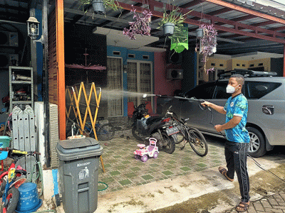 Sejumlah warga menyemprotkan cairan disinfektan secara mandiri di Perum Palm Village, Pamulang, Tangerang Selatan, Sabtu (5/2/2022).