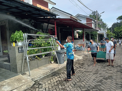 Sejumlah warga menyemprotkan cairan disinfektan secara mandiri di Perum Palm Village, Pamulang, Tangerang Selatan, Sabtu (5/2/2022).