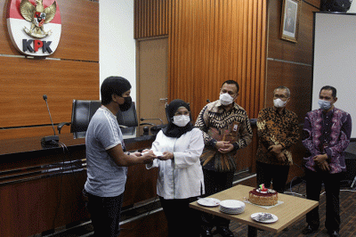 Ketua Komisi Pemberantasan Korupsi (KPK) Firli Bahuri, memberikan potongan kue kepada perwakilan jurnalis.
