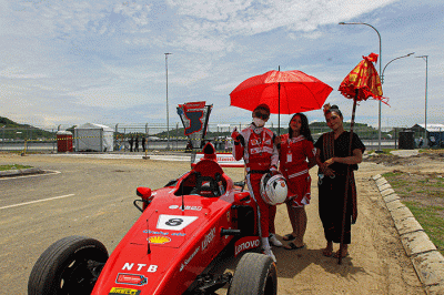 Michael Latip pembuat replika mobil balap F1 saat berpose layaknya pembalap di kawasan Sirkuit Mandalika, Lombok Tengah, NTB, Minggu (13/2/2022).