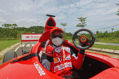 Michael Latip pembuat replika mobil balap F1 saat berpose layaknya pembalap di kawasan Sirkuit Mandalika, Lombok Tengah, NTB, Minggu (13/2/2022).