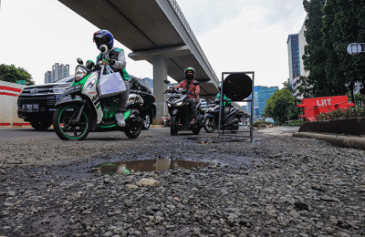 Kendaraan bermotor melintasi ruas jalan yang berlubang dan bergelombang di Jalan Rasuna Said, Jakarta Selatan, Rabu (16/2/2022).